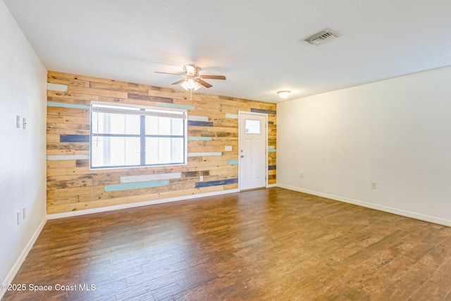 718 6th St, Merritt Island, FL 32953 - unfurnished room featuring wood walls, a ceiling fan, wood finished floors, and baseboards