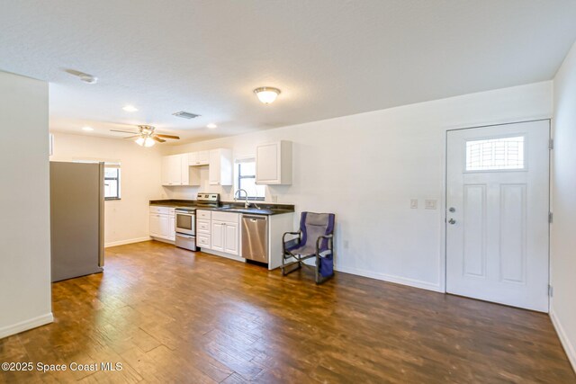 718 6th St, Merritt Island, FL 32953 - kitchen with stainless steel appliances, dark countertops, a sink, baseboards, and recessed lighting