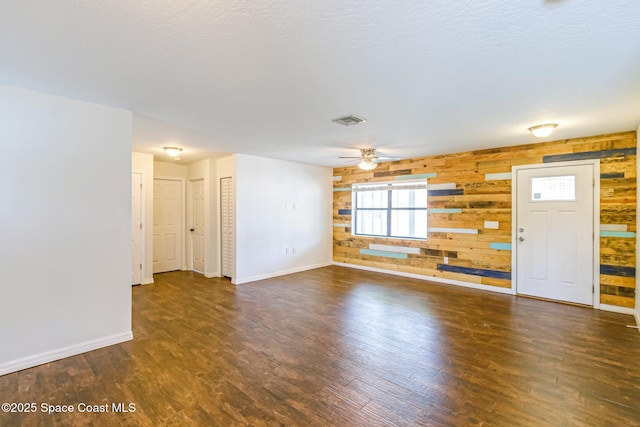 718 6th St, Merritt Island, FL 32953 - unfurnished living room with wood finished floors, baseboards, wood walls, and a ceiling fan
