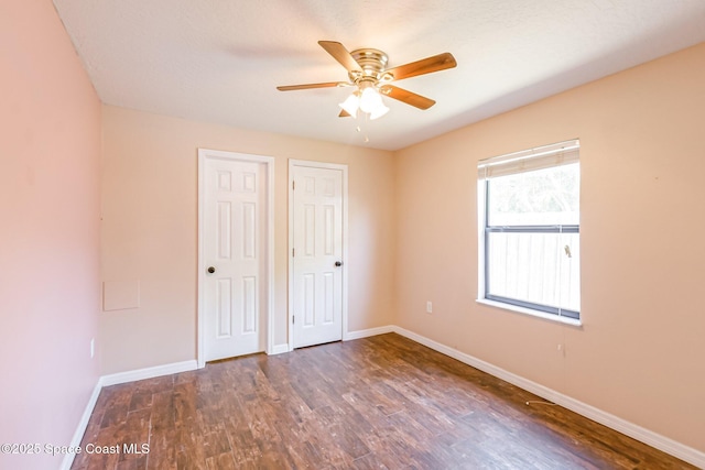 718 6th St, Merritt Island, FL 32953 - unfurnished bedroom with baseboards, wood finished floors, two closets, and ceiling fan