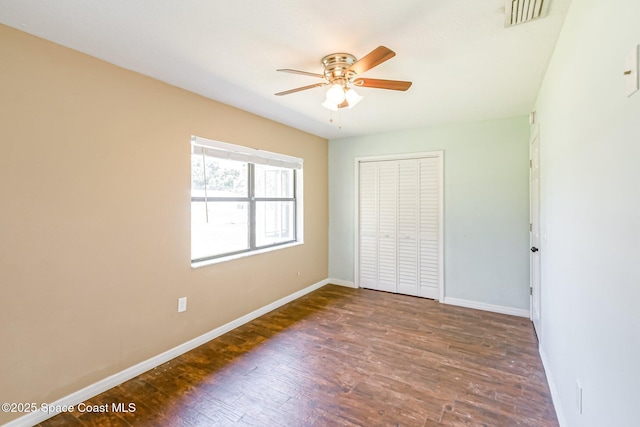 718 6th St, Merritt Island, FL 32953 - unfurnished bedroom with baseboards, wood finished floors, a closet, and ceiling fan