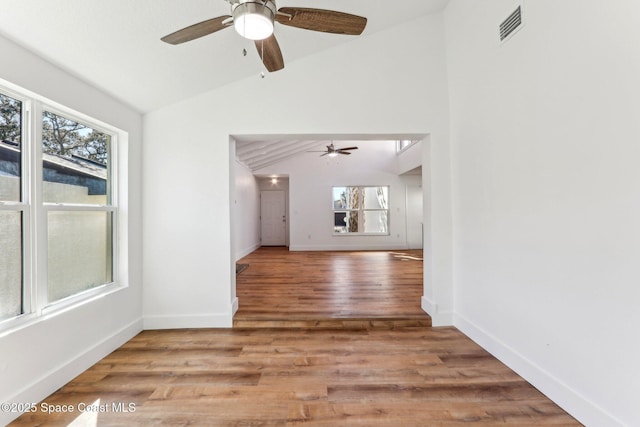 interior space with visible vents, a ceiling fan, lofted ceiling, and wood finished floors