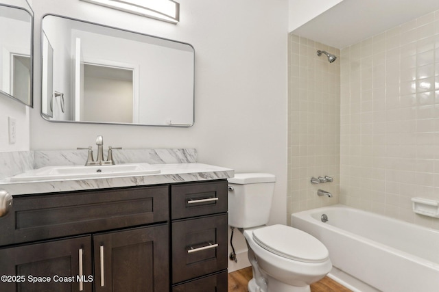 full bath featuring toilet, shower / washtub combination, wood finished floors, and vanity