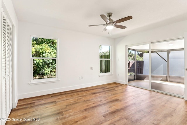 unfurnished bedroom featuring access to outside, wood finished floors, baseboards, and ceiling fan