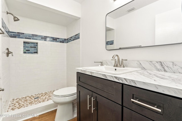 bathroom featuring vanity, wood finished floors, visible vents, a stall shower, and toilet