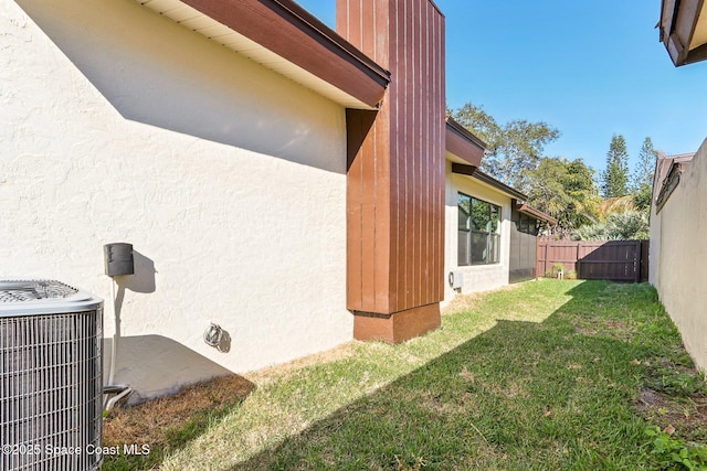 view of yard with fence and central AC