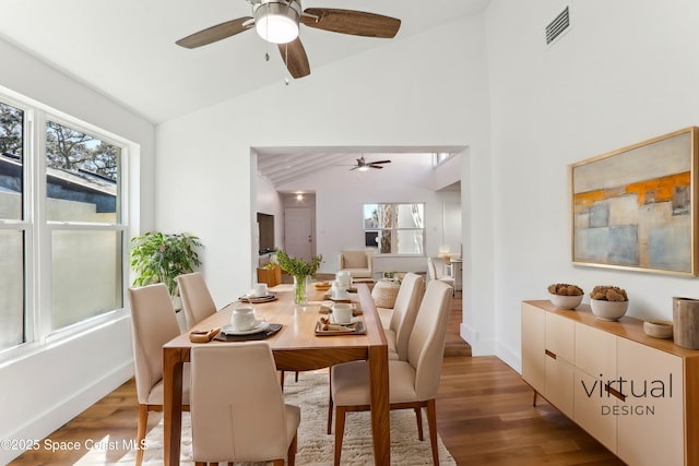 dining area with visible vents, light wood finished floors, a ceiling fan, and vaulted ceiling