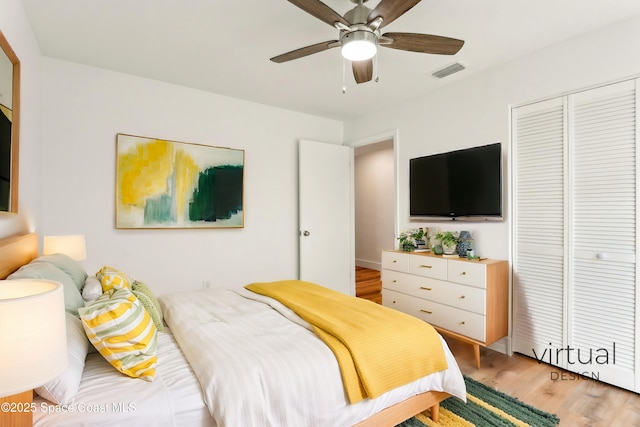 bedroom featuring light wood-type flooring, visible vents, a closet, and a ceiling fan