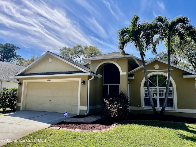 view of front of home featuring driveway, a garage, a front lawn, and stucco siding