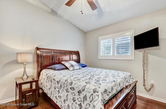 bedroom featuring a textured ceiling, a ceiling fan, baseboards, vaulted ceiling, and dark wood finished floors