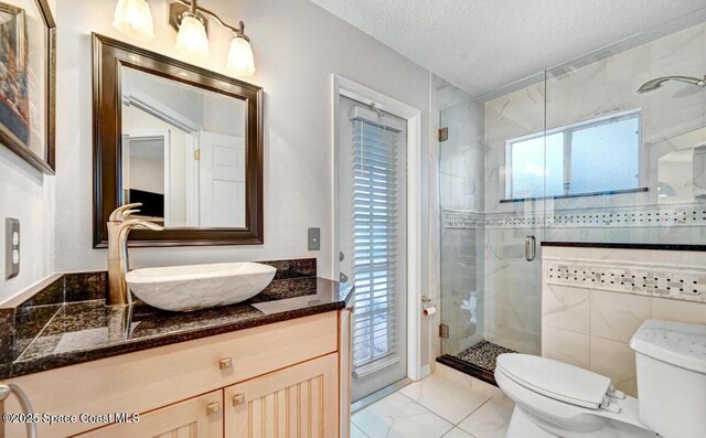 bathroom featuring toilet, a stall shower, marble finish floor, and a textured ceiling