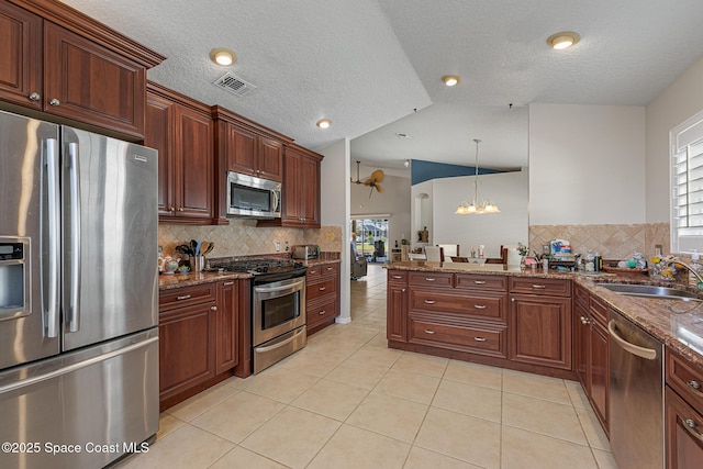 4983 Erin Ln, Melbourne, FL 32940 - kitchen with visible vents, lofted ceiling, light tile patterned floors, appliances with stainless steel finishes, and a sink
