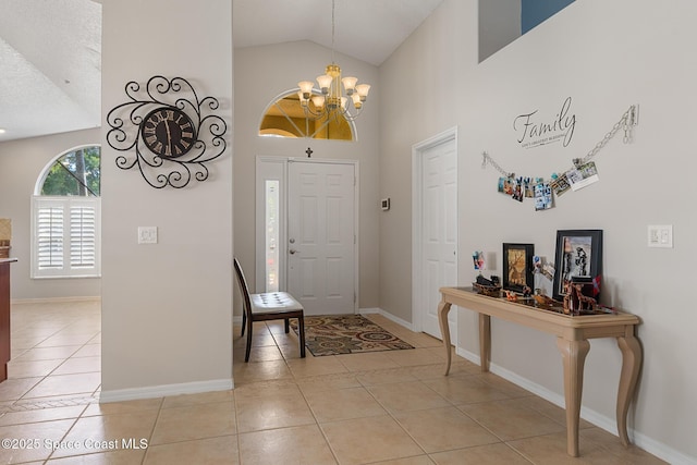 4983 Erin Ln, Melbourne, FL 32940 - entryway with high vaulted ceiling, light tile patterned floors, baseboards, and a chandelier