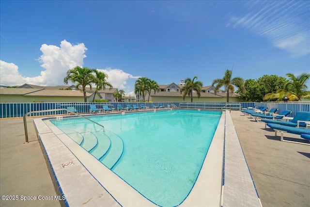 community pool with fence and a patio