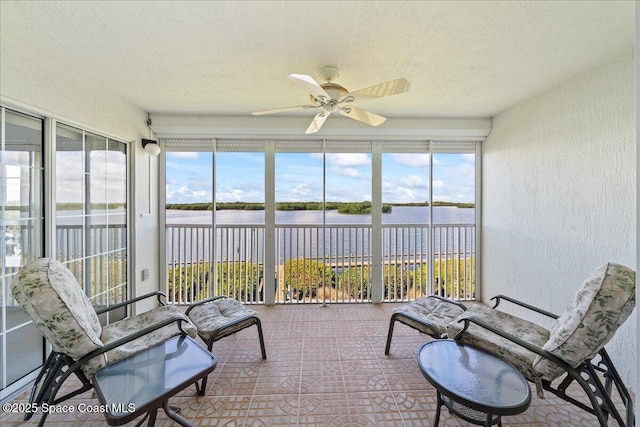 sunroom / solarium with a ceiling fan, a healthy amount of sunlight, and a water view