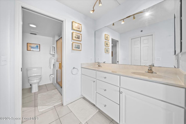 full bath with double vanity, tile patterned flooring, a sink, and toilet