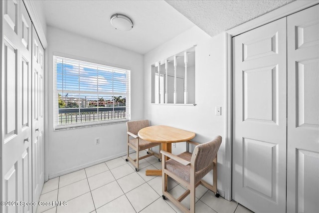 dining room with breakfast area, baseboards, and light tile patterned floors