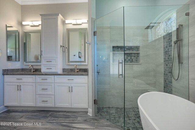 bathroom with a sink, double vanity, a soaking tub, and a shower stall