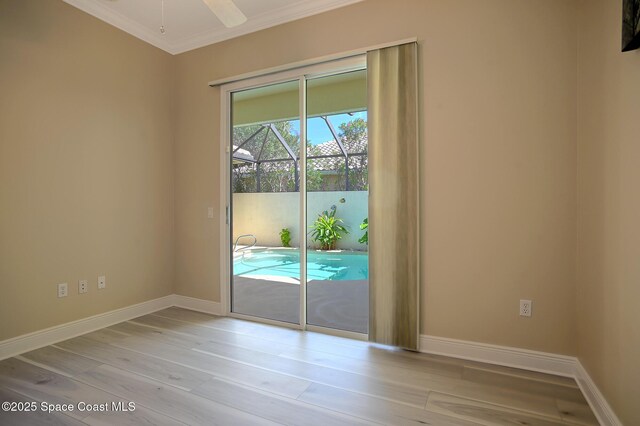 entryway with a ceiling fan, crown molding, baseboards, and wood finished floors