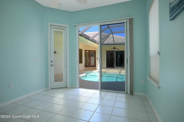 doorway to outside with ceiling fan, baseboards, and tile patterned floors