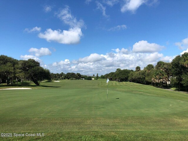 view of home's community with a lawn and golf course view