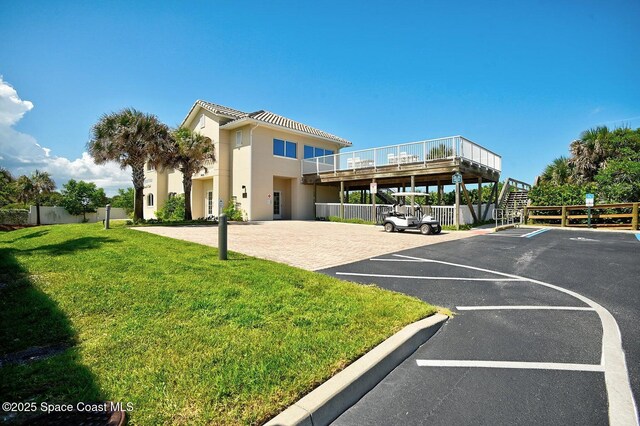 exterior space featuring stairs, fence, and a lawn