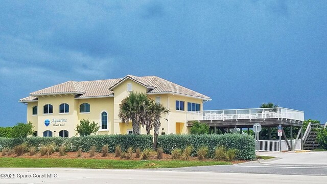 exterior space with a tiled roof and stucco siding