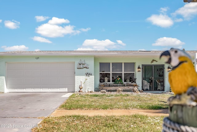 view of front of home with an attached garage, concrete driveway, and brick siding