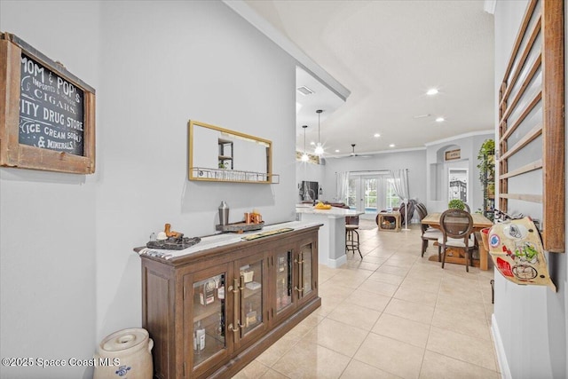 hall with light tile patterned floors, visible vents, baseboards, ornamental molding, and recessed lighting