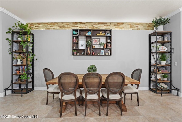 tiled dining space with baseboards and ornamental molding