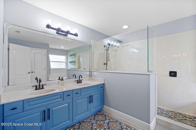 bathroom featuring double vanity, a walk in shower, and a sink