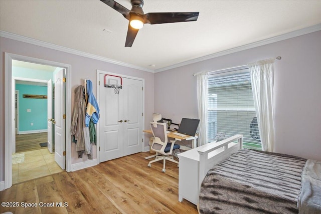 bedroom with ensuite bathroom, ornamental molding, light wood-style flooring, and baseboards