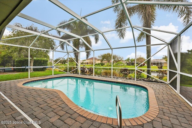 outdoor pool featuring a patio and glass enclosure