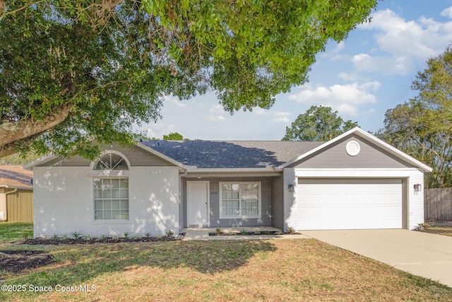 ranch-style home featuring fence, concrete driveway, a front lawn, a garage, and brick siding