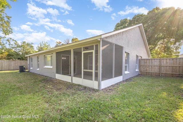 rear view of property featuring a lawn, cooling unit, a fenced backyard, and stucco siding