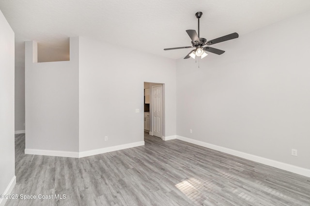 unfurnished room featuring ceiling fan, baseboards, and wood finished floors