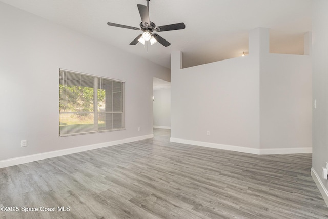 spare room featuring a ceiling fan, baseboards, and wood finished floors