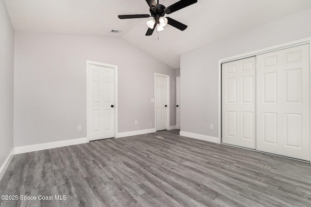 unfurnished bedroom with a ceiling fan, wood finished floors, visible vents, baseboards, and lofted ceiling