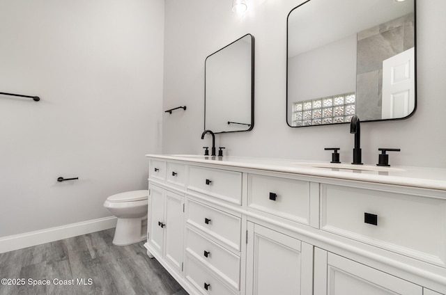 full bath with a sink, baseboards, toilet, and wood finished floors