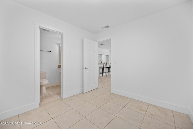 unfurnished bedroom featuring light tile patterned floors, baseboards, and visible vents