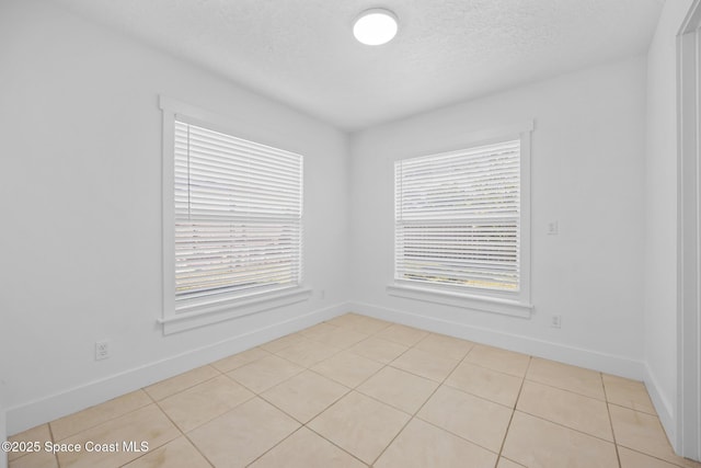 unfurnished room with baseboards, a textured ceiling, and tile patterned floors