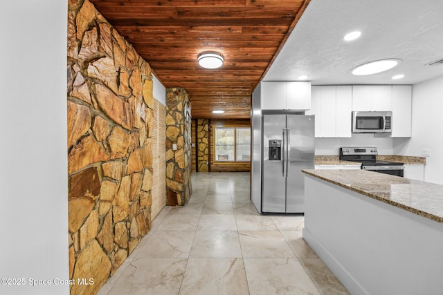 kitchen with light stone countertops, appliances with stainless steel finishes, wood ceiling, white cabinetry, and modern cabinets