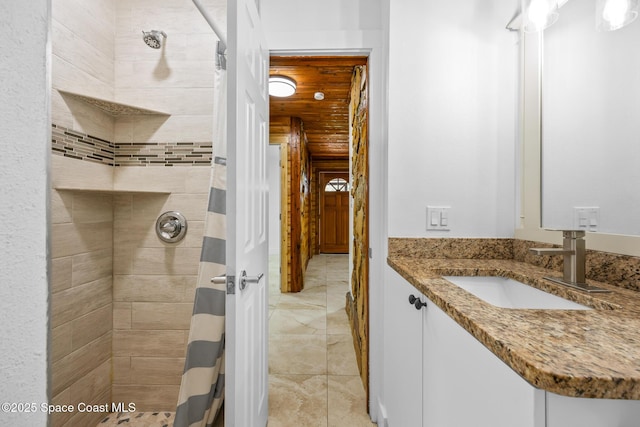 bathroom featuring tiled shower and vanity