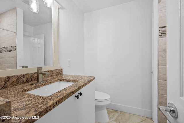 bathroom with toilet, baseboards, and vanity