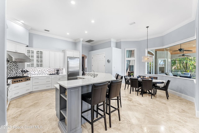 kitchen with under cabinet range hood, open shelves, stainless steel appliances, white cabinets, and decorative backsplash