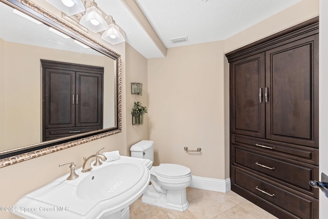 bathroom featuring baseboards, visible vents, a sink, tile patterned flooring, and toilet