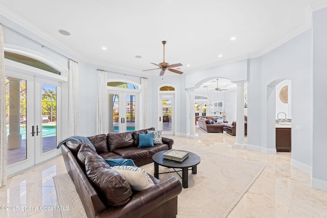 living area with decorative columns, french doors, baseboards, and a healthy amount of sunlight