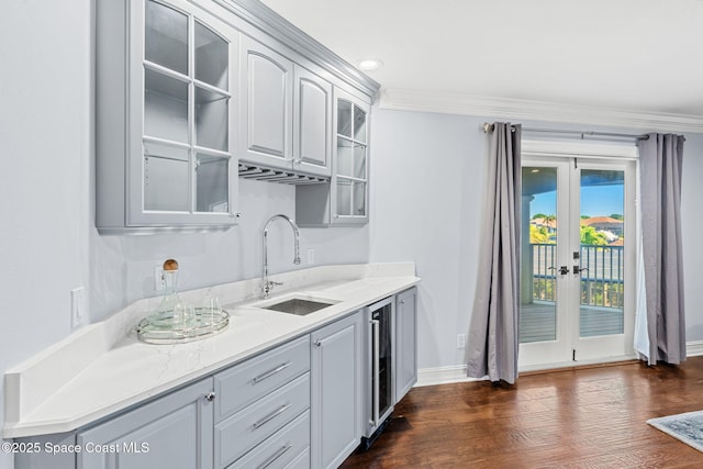 kitchen with beverage cooler, a sink, dark wood finished floors, french doors, and glass insert cabinets