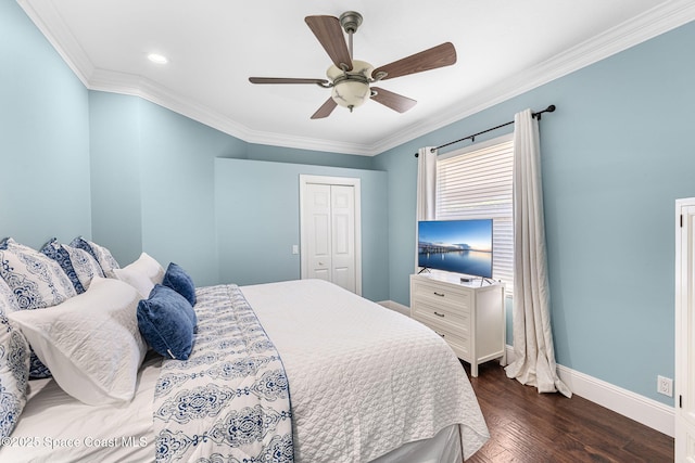 bedroom with a closet, baseboards, ornamental molding, and dark wood-style flooring