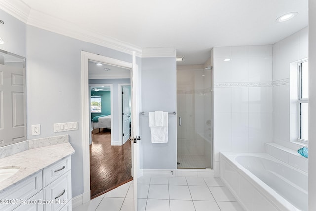 ensuite bathroom with tile patterned floors, a stall shower, ensuite bathroom, ornamental molding, and vanity